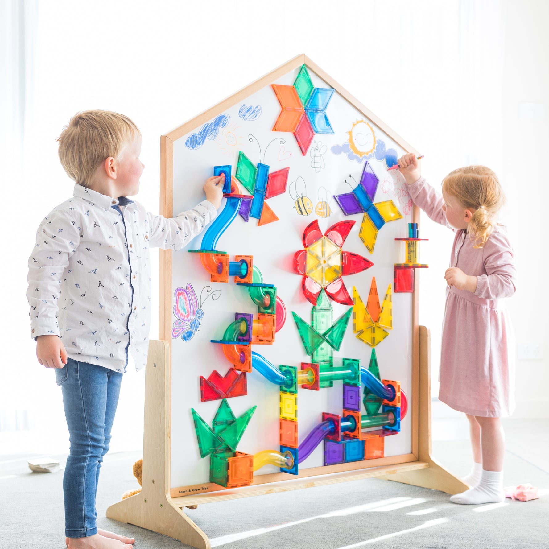 Children playing on the learn & grow toys mutli-board sitting in a light filled playrom