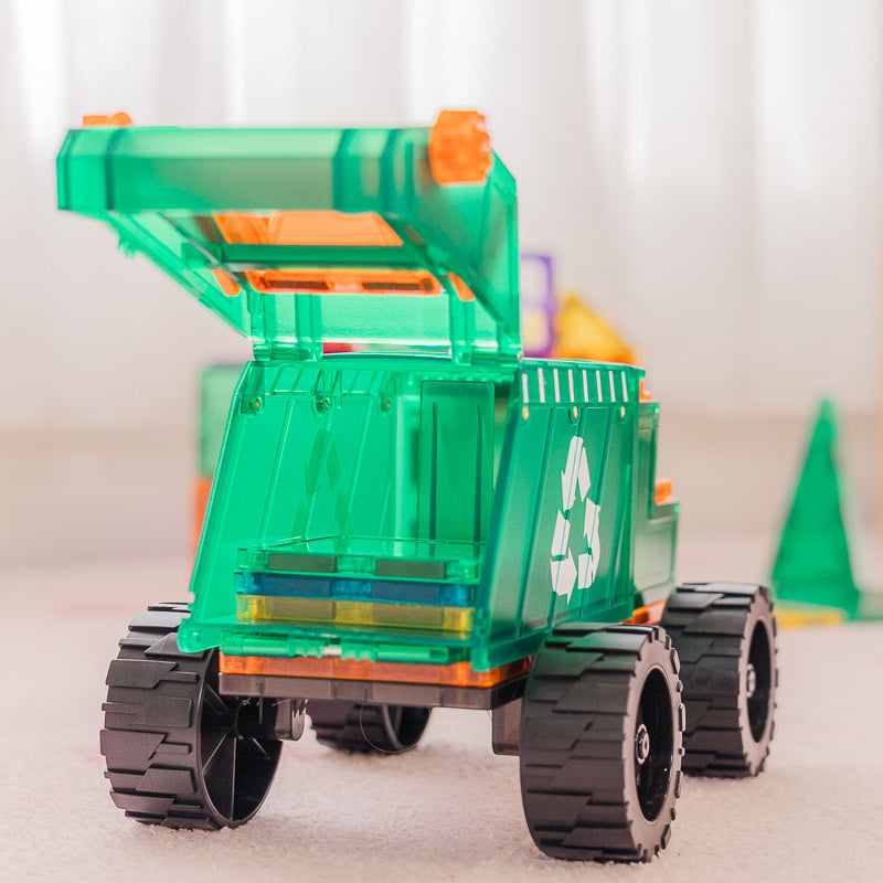 Toy magentic tile dump truck in a room with books and toys