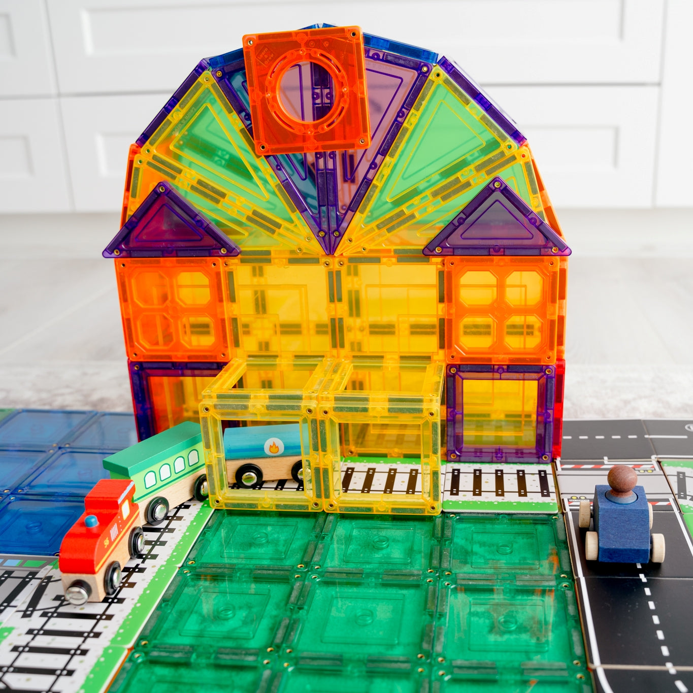 Colourful_station_made_from_learn_and_grow_magnetic_tiles_set_up_with_train_and_road_toppers