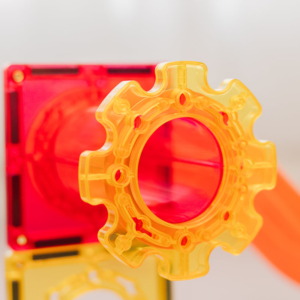 Close-up of a yellow gear-shaped object with a red background for ball run