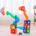 Rainbow coloured marble run toy set on a carpet floor with a blurred background