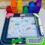 road and train toppers set up outside on table with colourful magnetic tile houses and hey doodle mat sitting in middle 