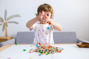 Metal Rimmed Counting Chips for counting, sensory and creative play with child playing and dropping counting chips on table