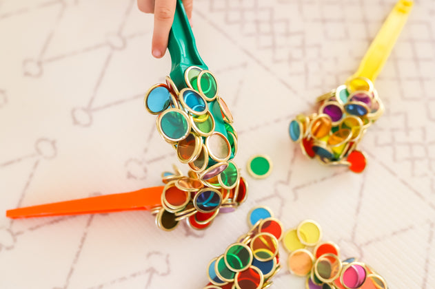 Colourful magnetic wands and metal rimmed counting chips used by children for sensory play